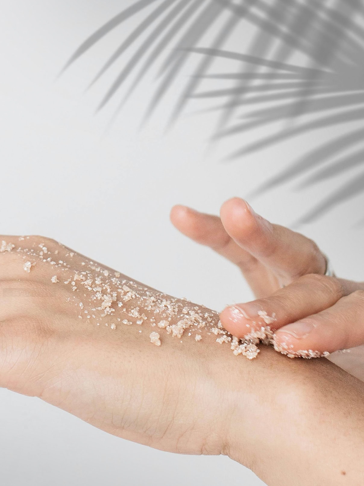 a person's hand showing how to use sugar scrub